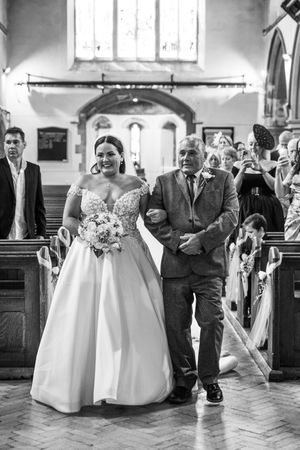 A sequence of black and white photographs showing a wedding procession walking down the church aisle.