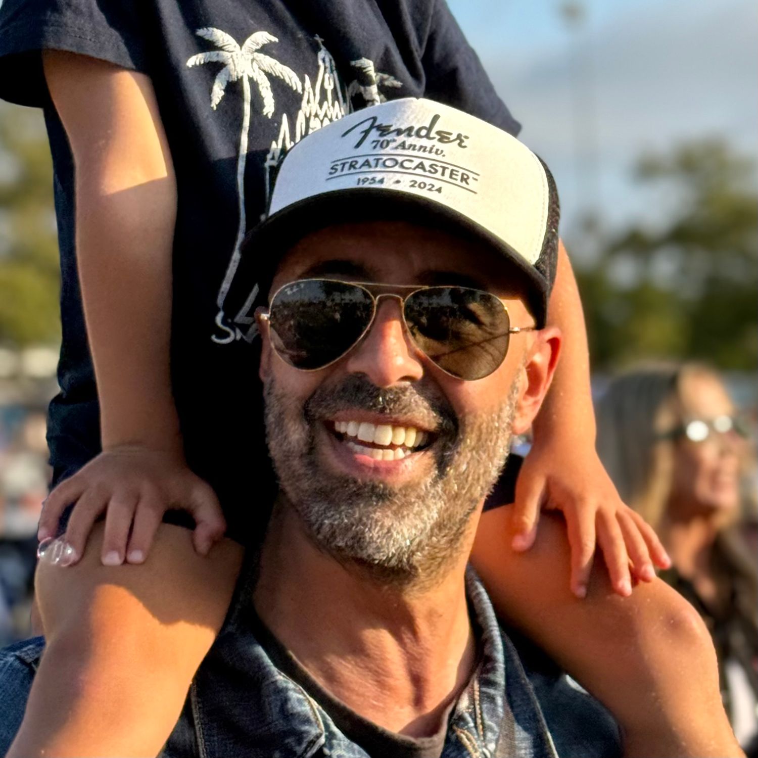 Headshot of Mariano Alvarez with his son on his shoulders, he is a Newport Beach family and lifestyle photographer