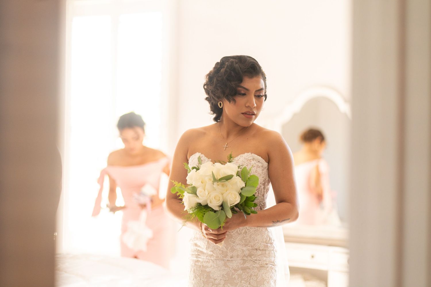 Elegant wedding party members in formal attire pose indoors with natural lighting.