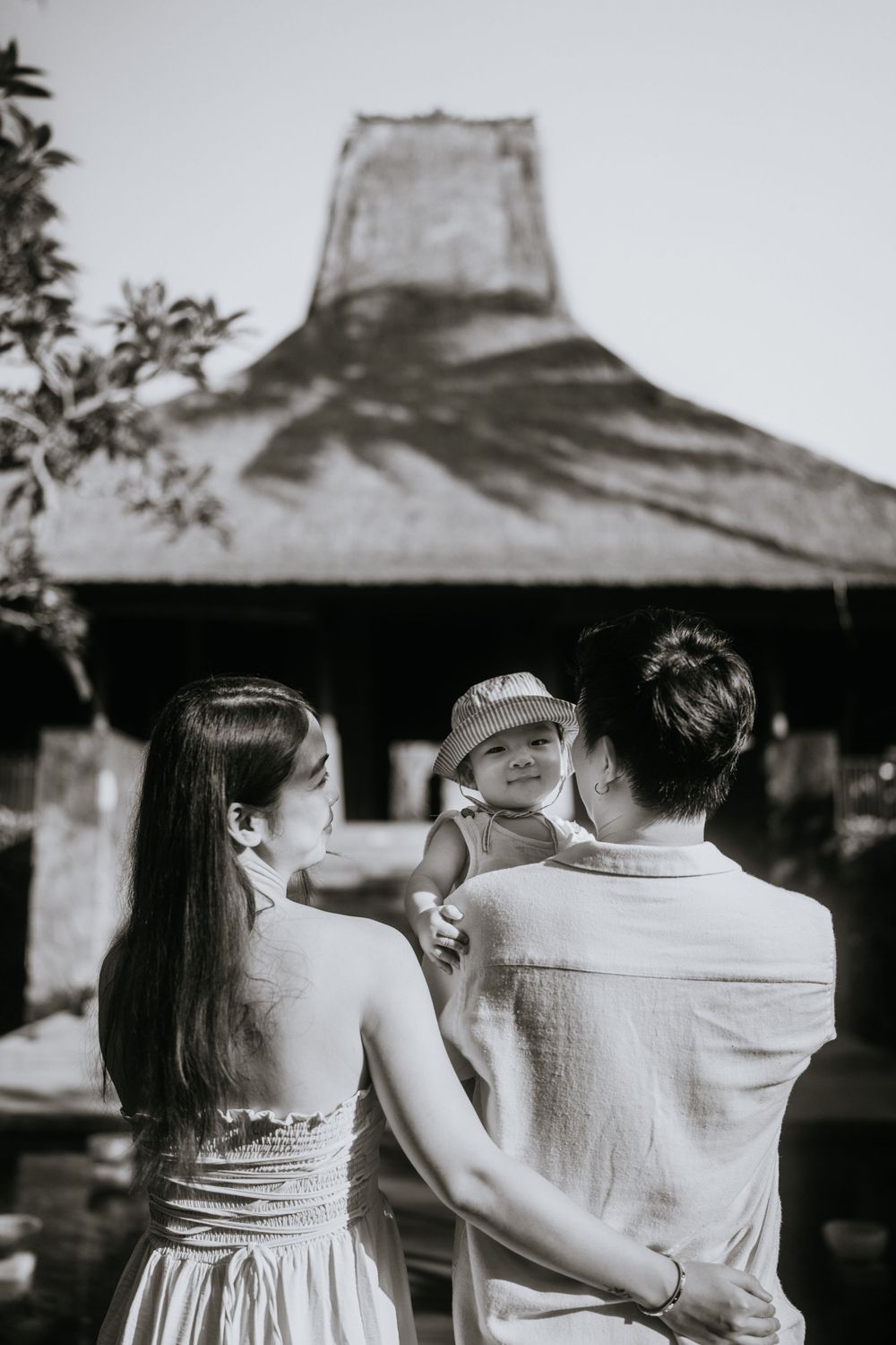 Black and white photo showing people from behind against architectural backdrop.