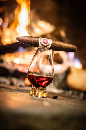 Close-up shots of whiskey glasses with cigars in warm lighting creating a luxurious ambiance.