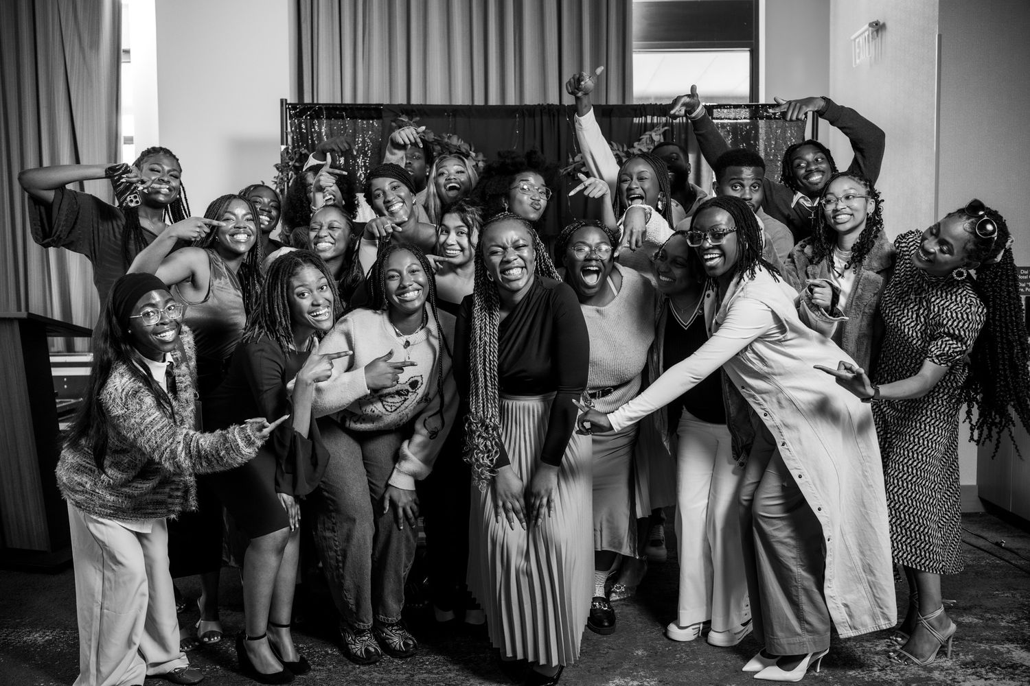 Black and white photo capturing a celebratory moment at an indoor gathering.