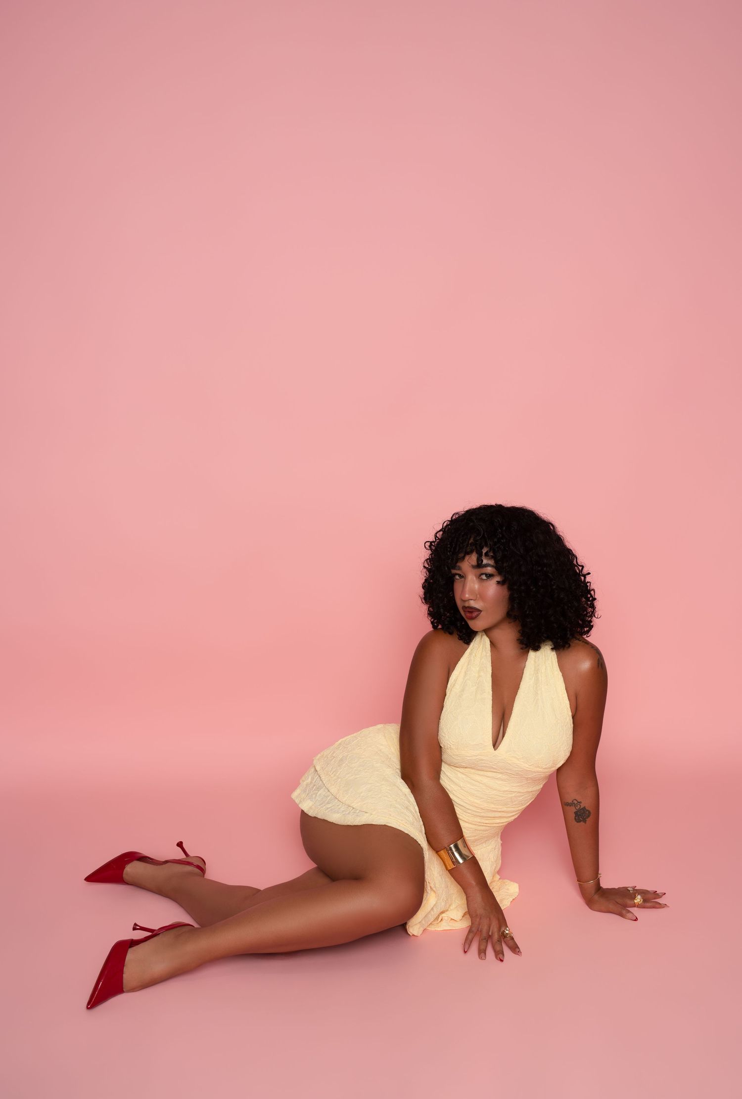 A figure in a yellow dress strikes graceful poses against a pink backdrop in this series of artistic photographs.