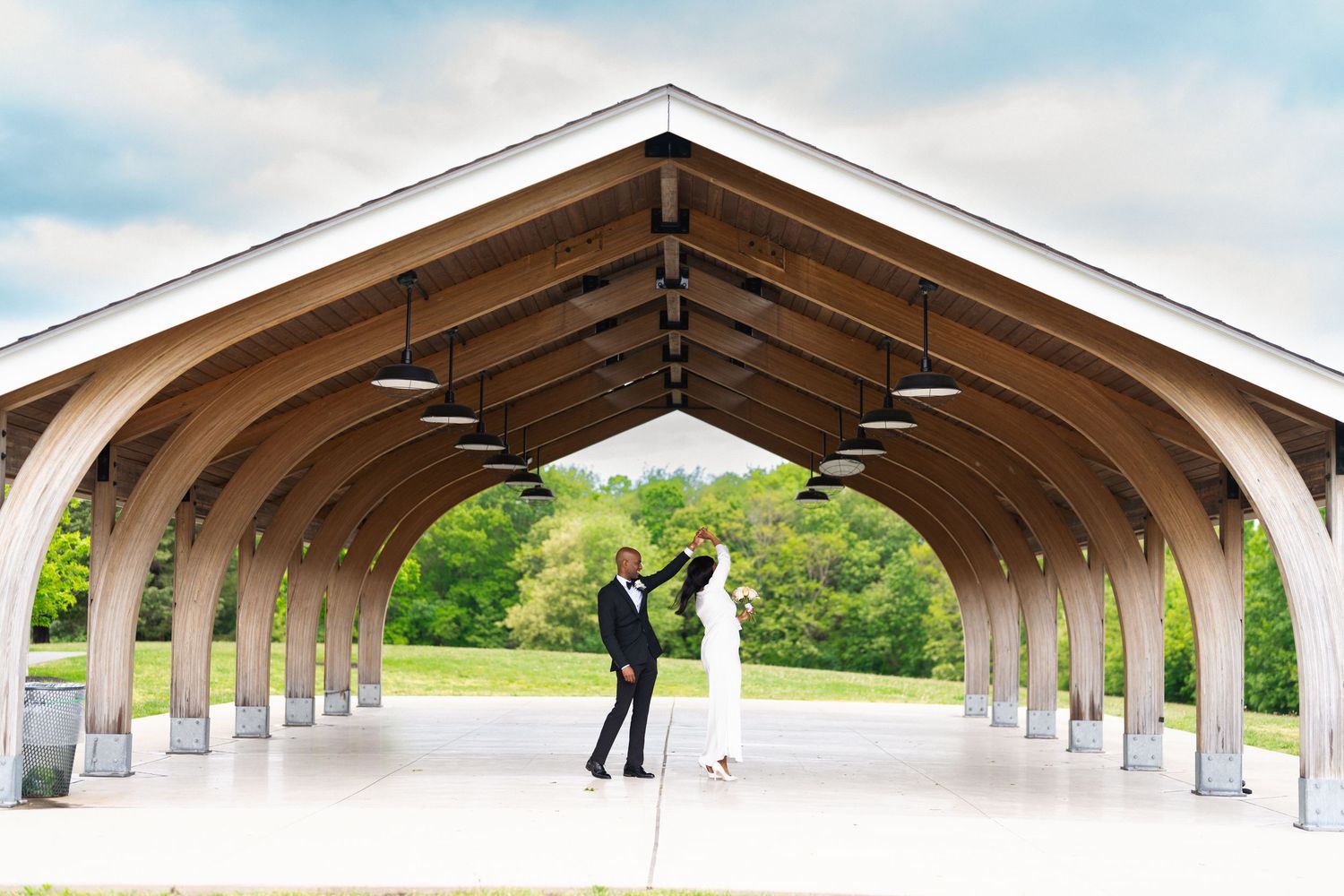 A series of architectural images showing a curved concrete walkway structure with arched supports against a blue sky.