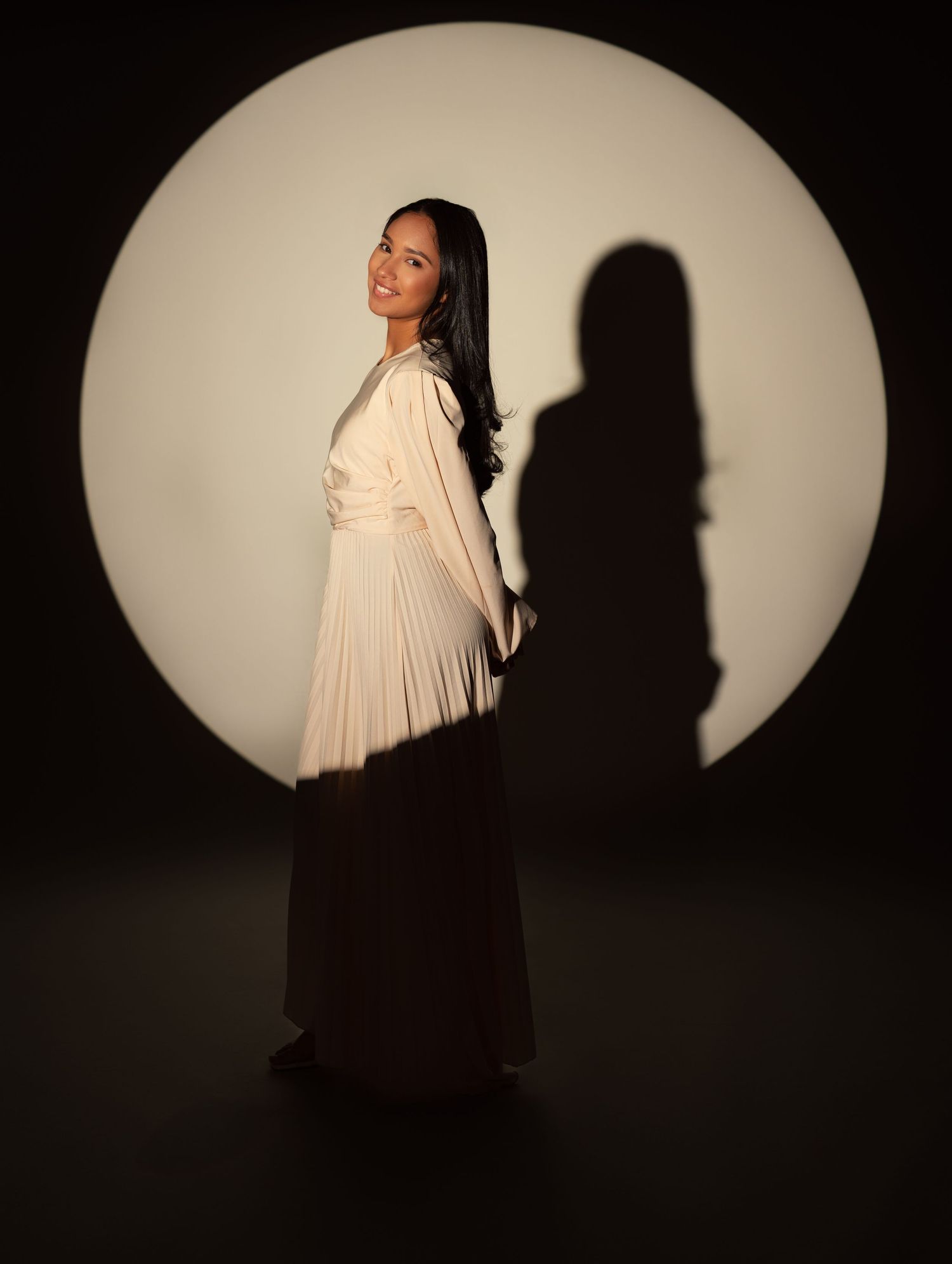 Artistic portrait series showing a figure in flowing white fabric against dark background with dramatic lighting and shadows.