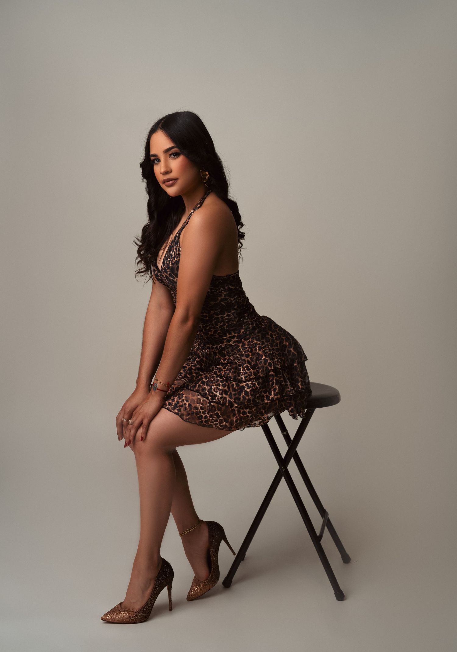 Stylish sequence of poses showcasing a sparkling brown mini dress and neutral heels against a minimalist studio backdrop.