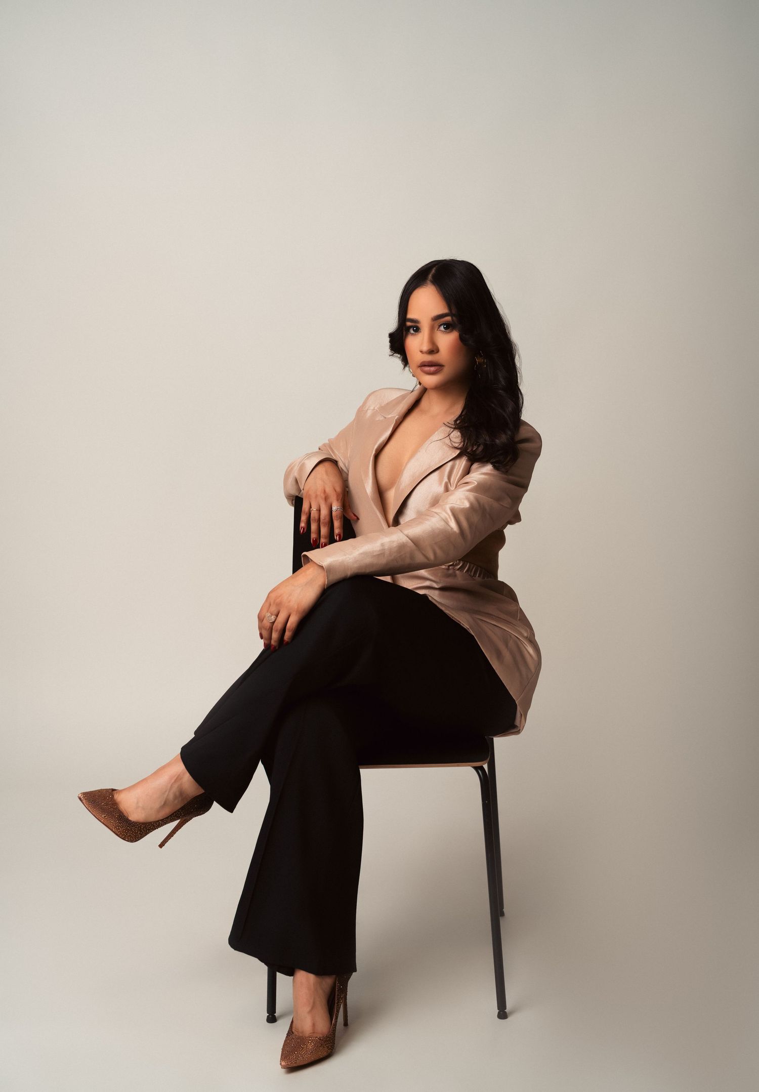 Professional fashion photoshoot on grey backdrop showcasing business casual attire and elegant poses.