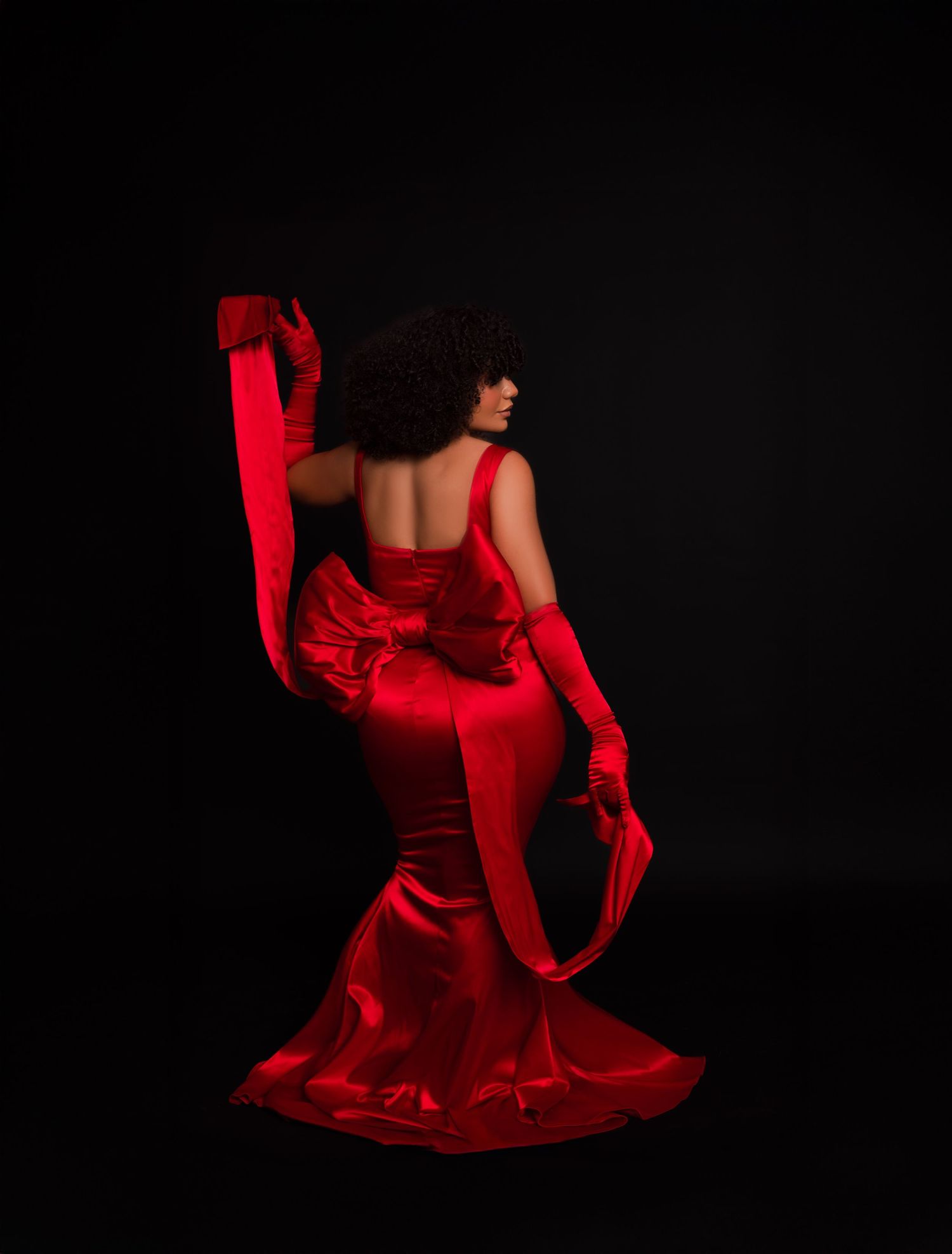 A dancer in a flowing red dress performs dramatic movements against a dark background in a series of artistic shots.