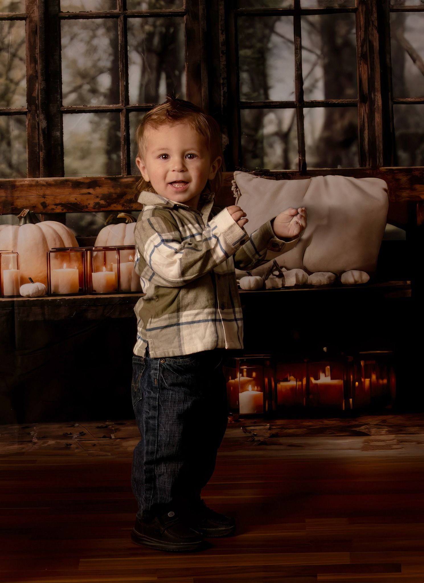 Young child in denim and beige sweater walks through dim rustic interior with vintage windows in background. halloween decorations