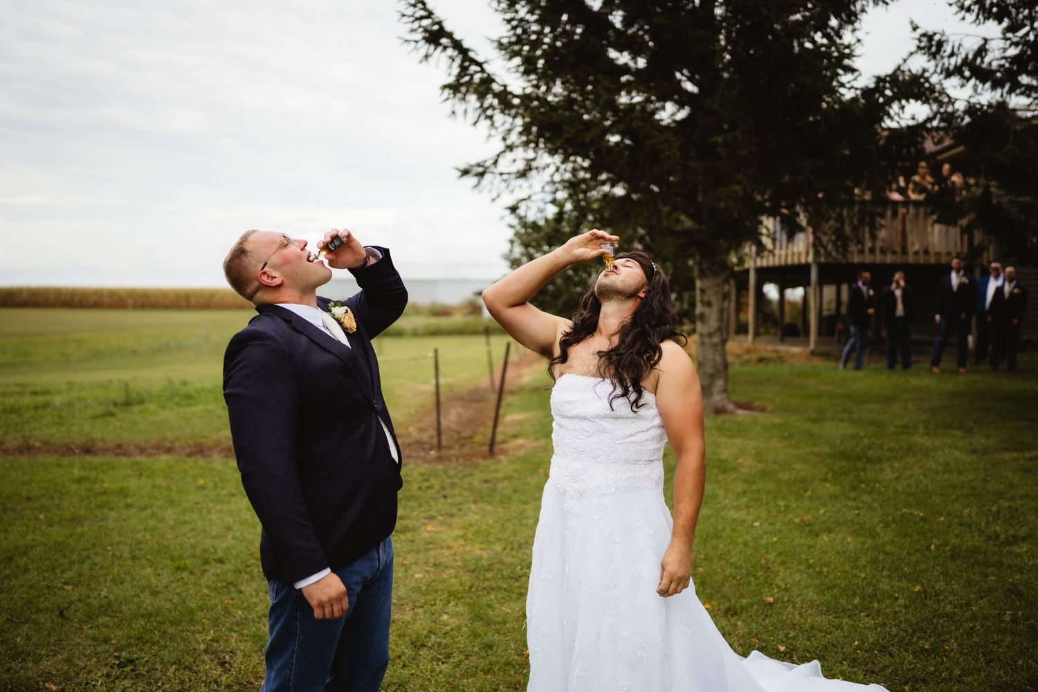 Bride and groom share a romantic moment in a rustic countryside setting at sunset.