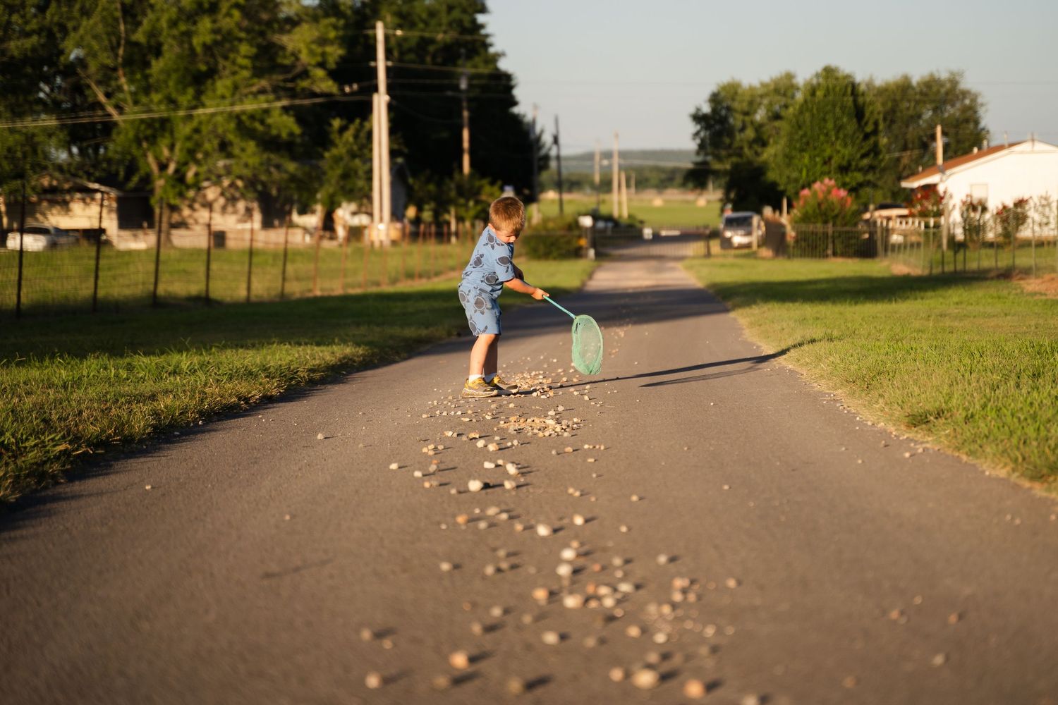 Young farm kid pretending to help with chores during a documentary family photography session by Tulsa photographer