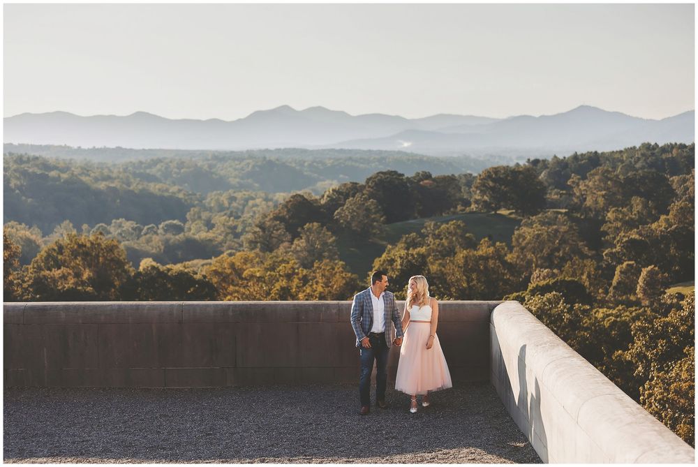Scenic mountain landscape with wedding couple silhouetted against rolling hills and golden sunlight at sunset.