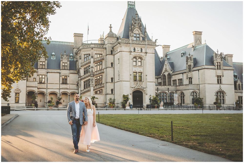 A couple strolls along the path in front of the majestic Biltmore Estate mansion in Asheville, North Carolina.