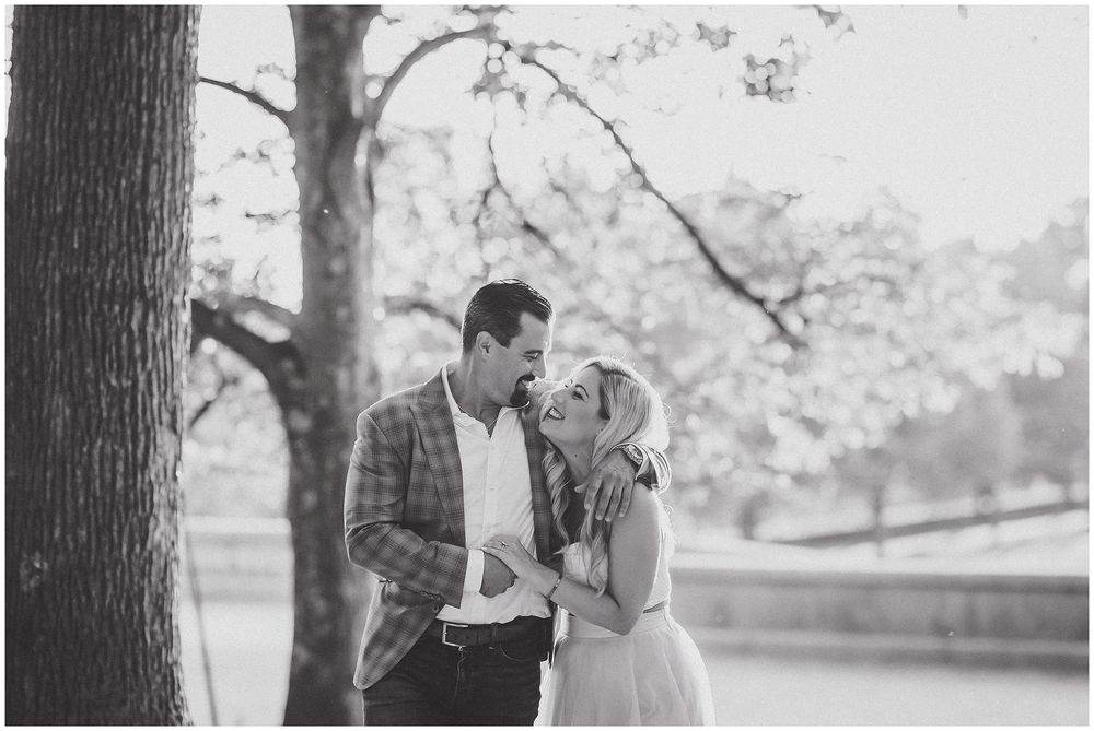 Black and white photos of a couple in a romantic outdoor setting sharing intimate moments near trees.