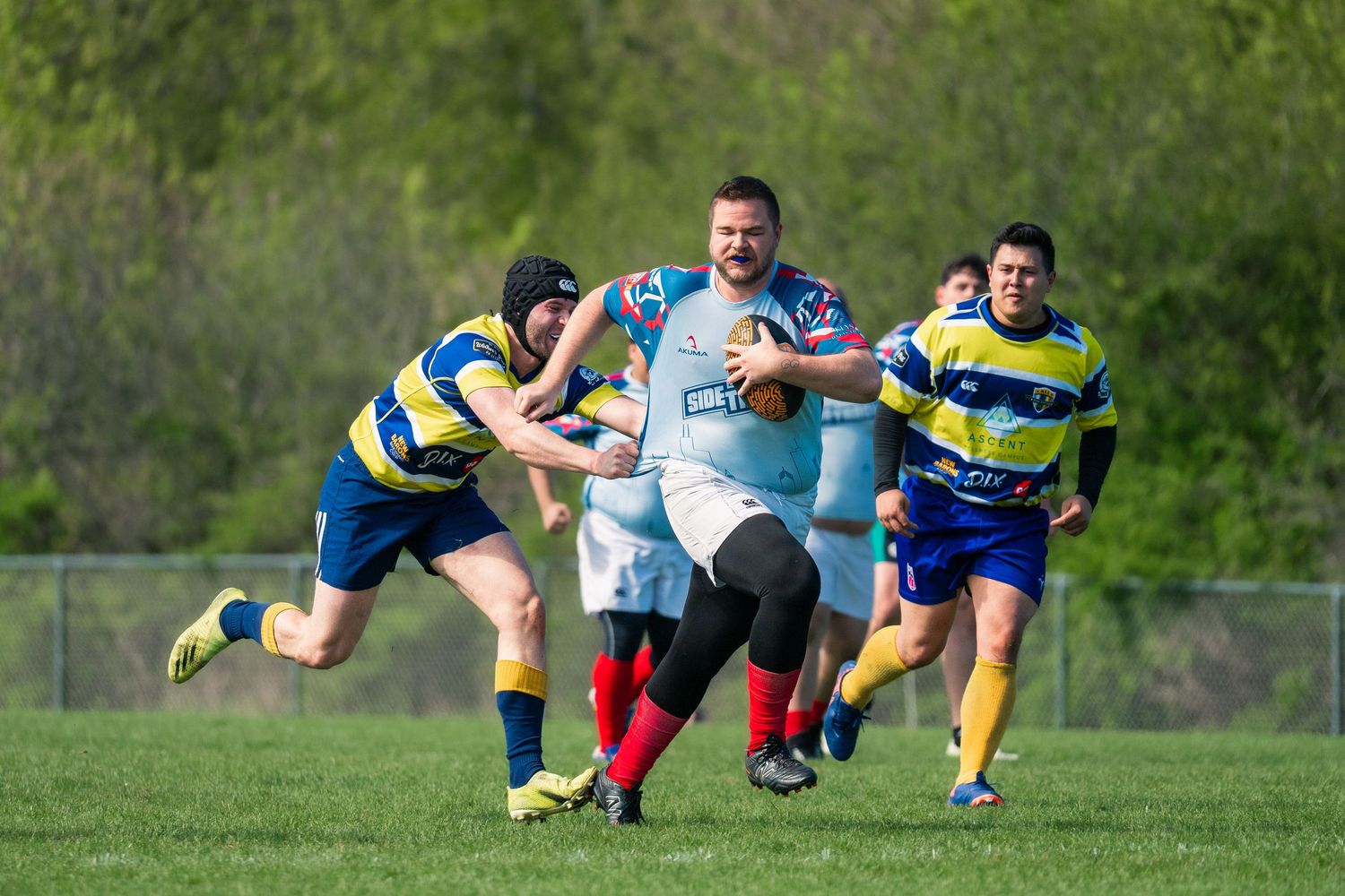 Two rugby athletes attempt to catch an incoming ball thrown in from the sidelines to restart the match