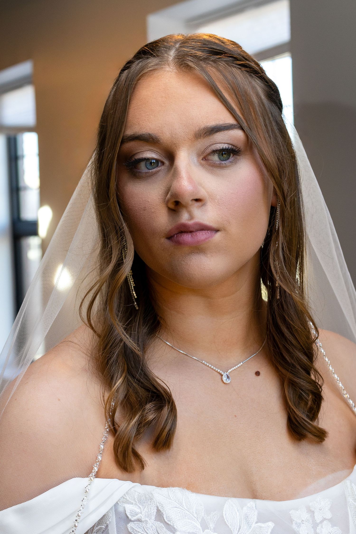 A bridal portrait series showing close-up shots in a white wedding dress and veil against a light background.