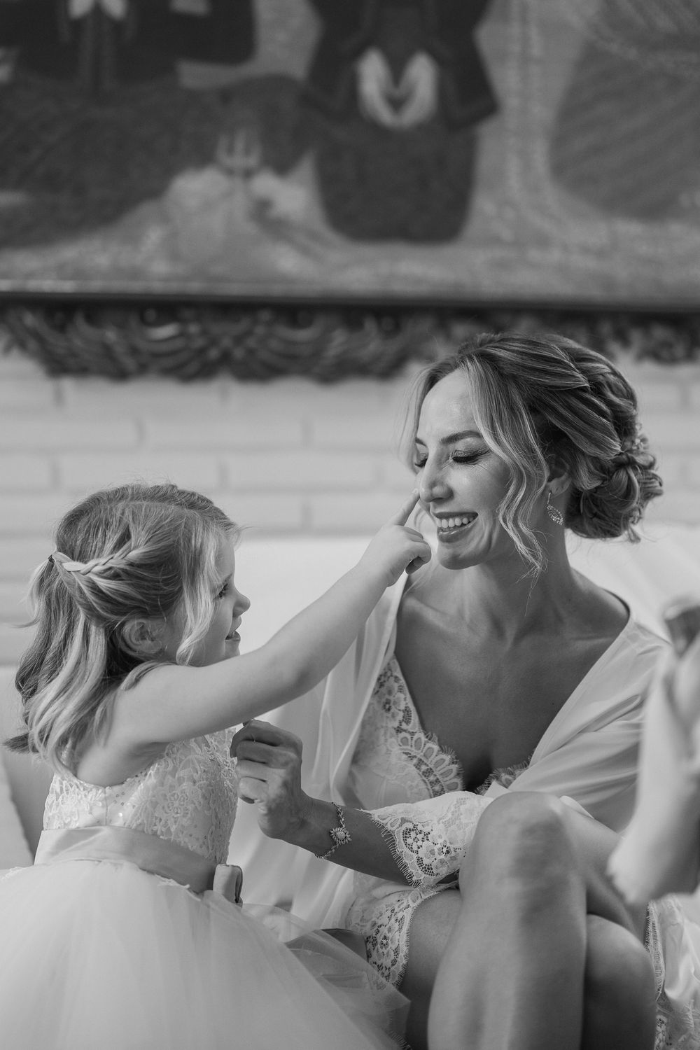 Black and white candid moment between two people during wedding preparations.
