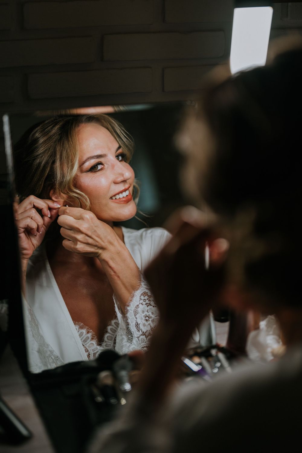 An intimate candid moment captured during a wedding reception in low light.