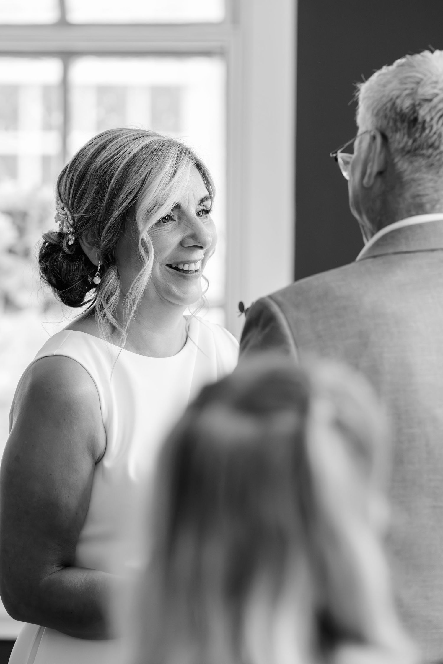 A bride and groom share romantic kisses in a series of black and white wedding photographs outdoors.