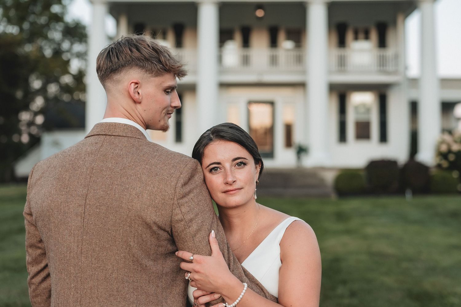A romantic close up photo of a couple about to kiss at their wedding outdoors.