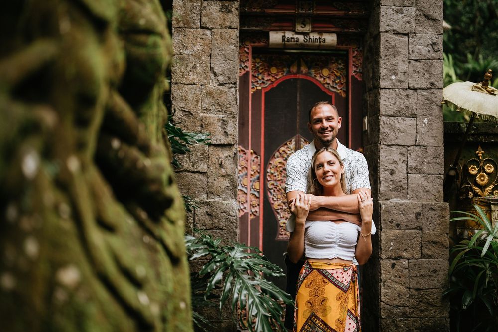 A rustic stone building entrance surrounded by tropical plants and natural landscaping.