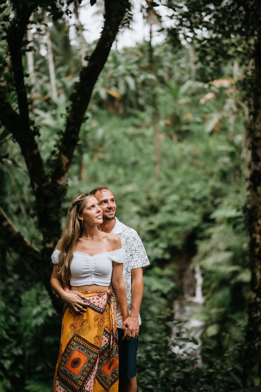 A romantic outdoor photoshoot in a lush green forest setting.