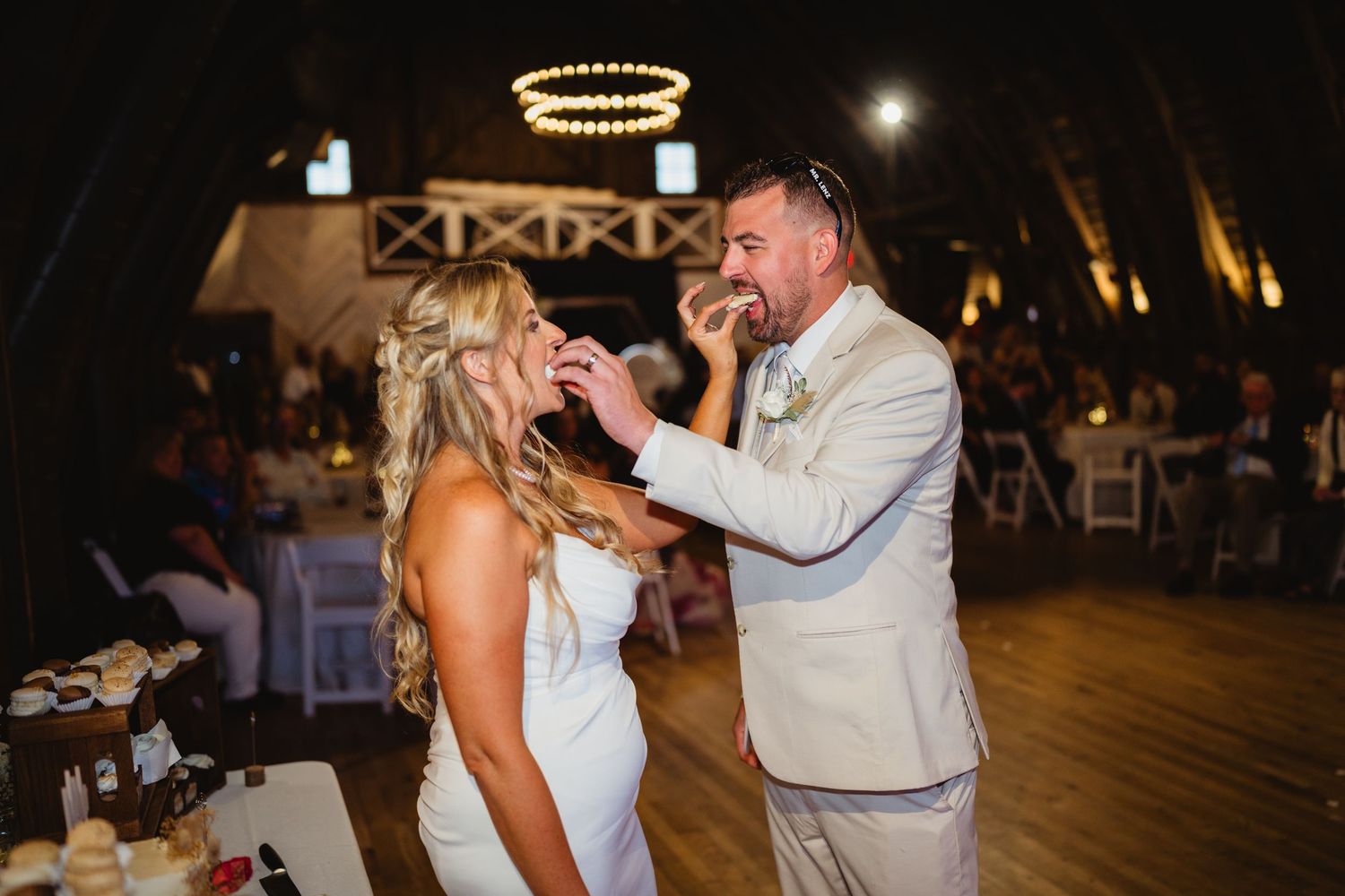 People dancing and celebrating together at an indoor wedding reception under warm lighting.