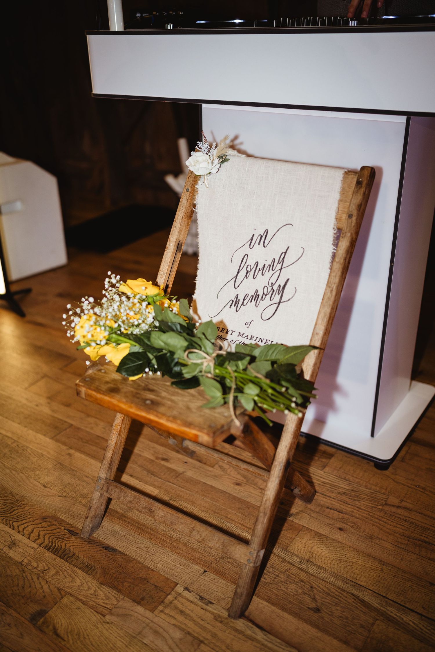 Rustic wooden sign holder with fresh floral accents and calligraphy cards on a hardwood floor captured in sequence.