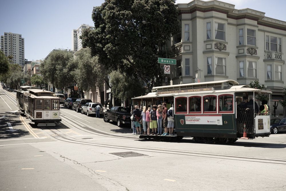 Panoramic street view of San Francisco's steep hills with historic buildings and trolley tracks.