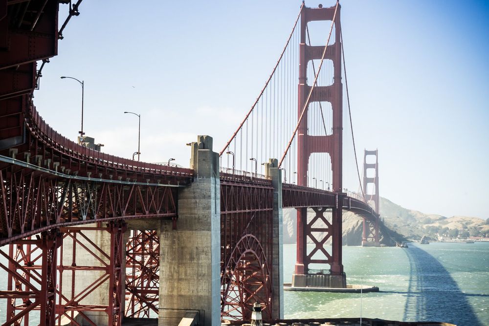Multiple panoramic views of the iconic Golden Gate Bridge in San Francisco against blue skies and ocean.