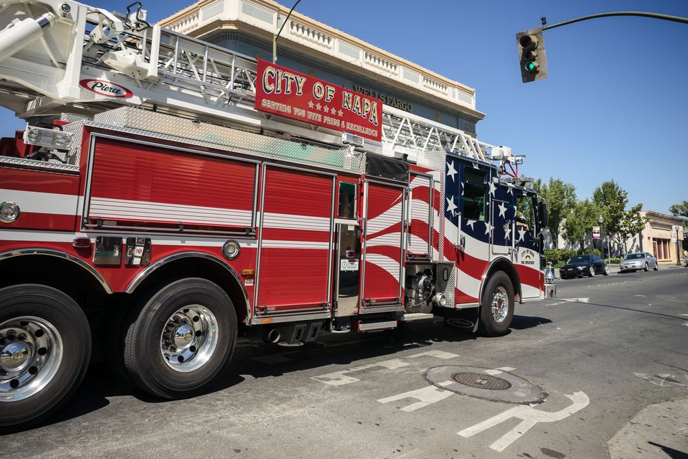 A long line of red and white fire trucks parked in a row at a fire station.