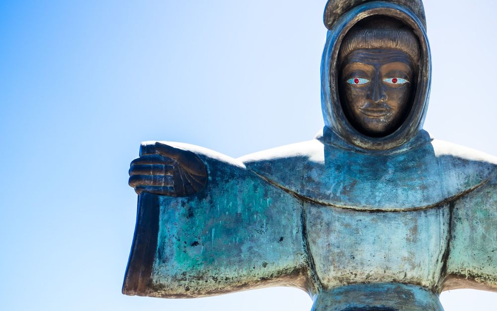 A series of old wooden angel figures with weathered blue paint and carved features arranged in a horizontal row.
