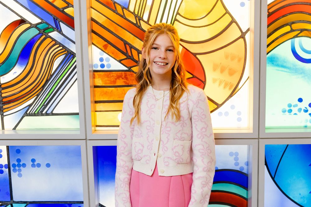Wedding party photos captured in front of colorful stained glass windows with abstract geometric designs.