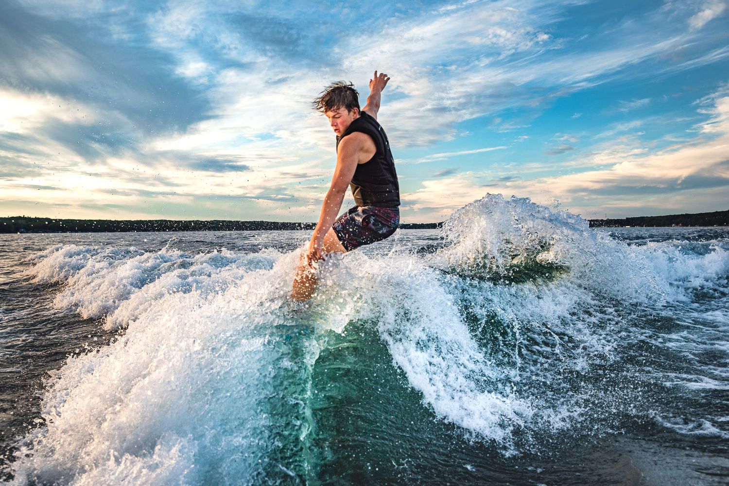 Dynamic sequence showing a wakeboarder performing an aerial flip trick over turquoise water on a sunny day.