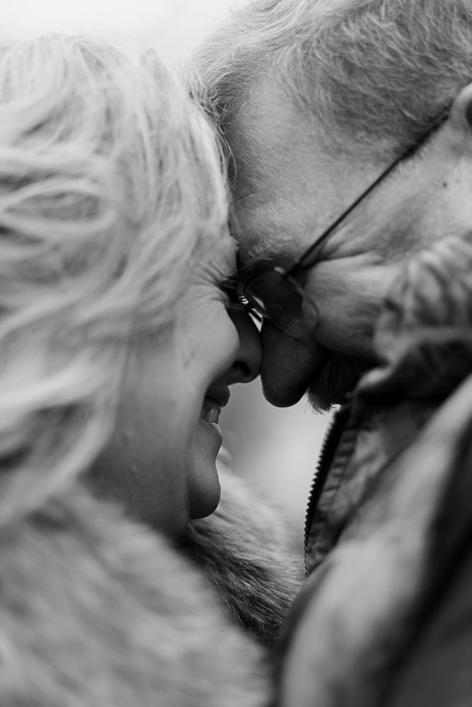 Intimate black and white close-up portrait of couple touching noses.