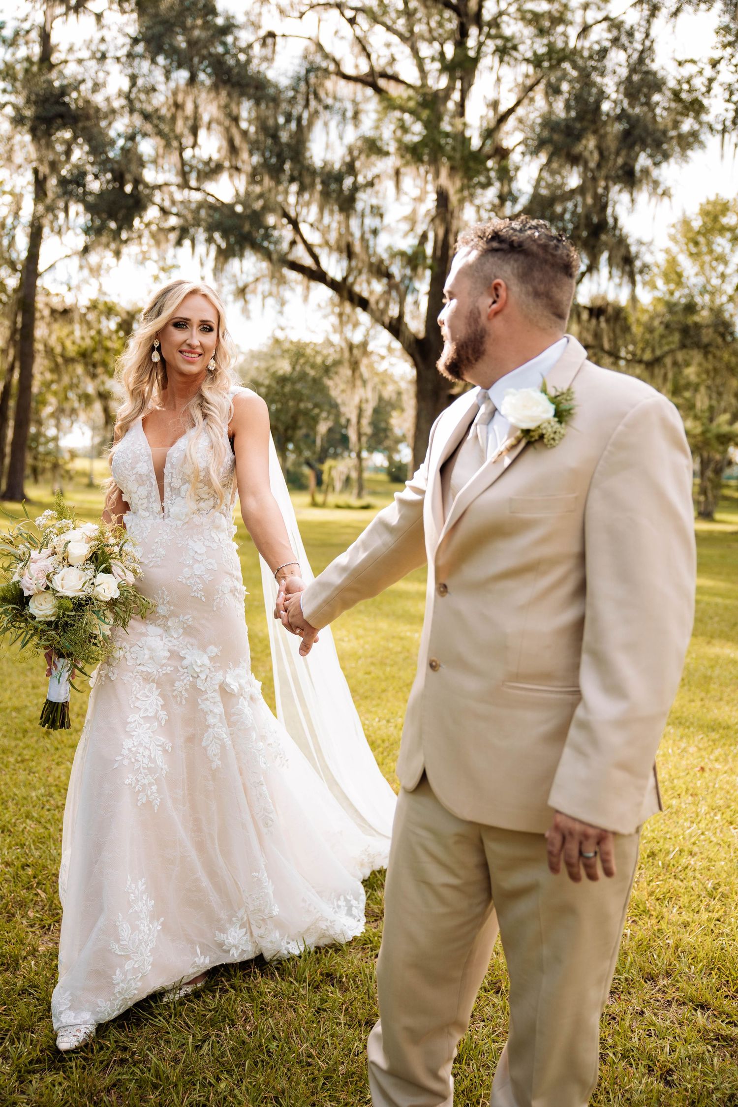 Wedding photography series showing a couple in beige and white attire posing playfully on grass.