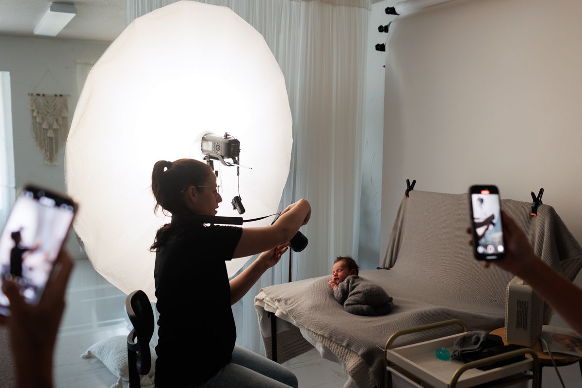 Professional photography studio setup showing lighting equipment and white backdrop.