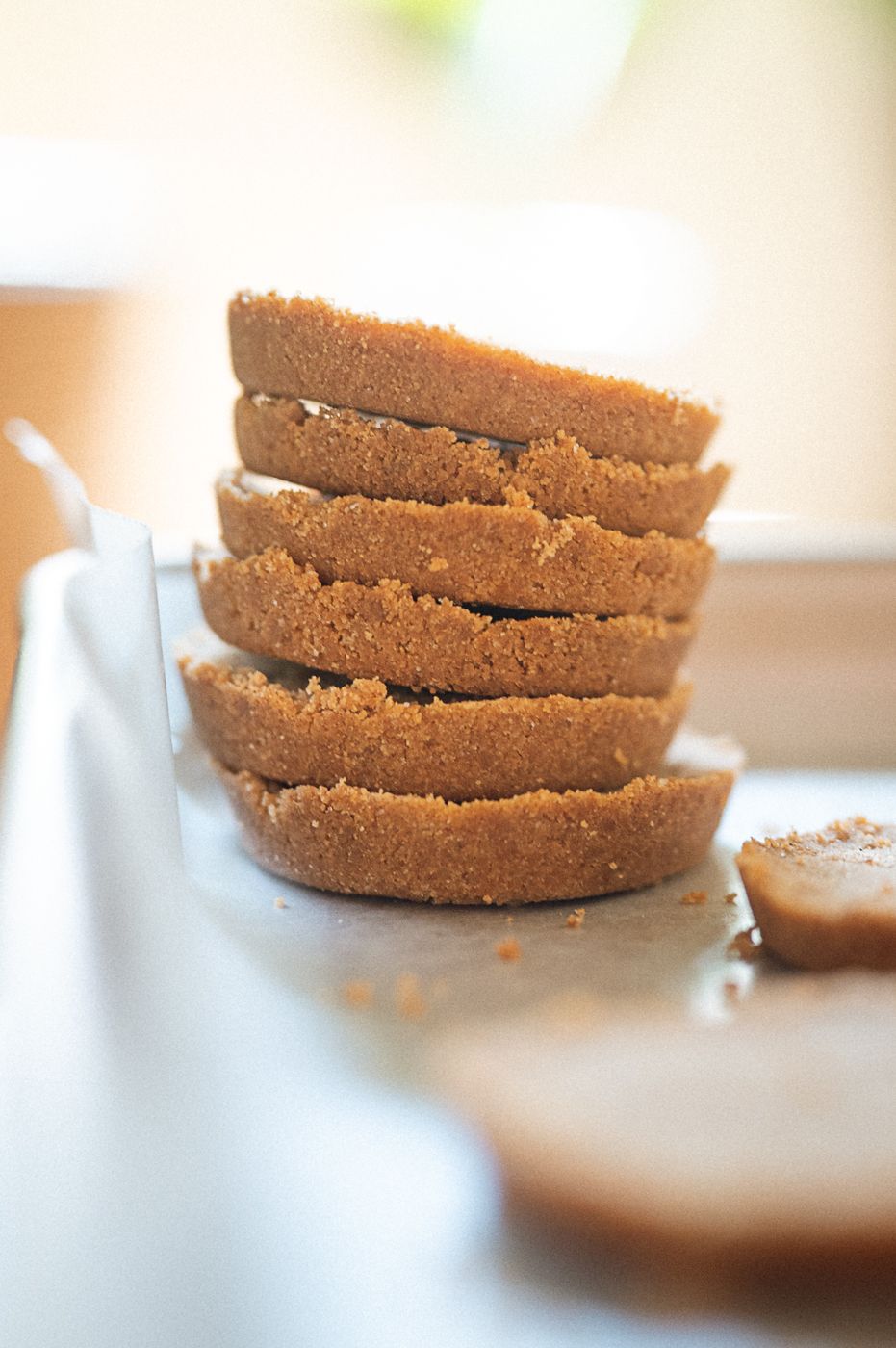Stack of freshly baked brown sugar cookies resting on white surface with soft focus background.
