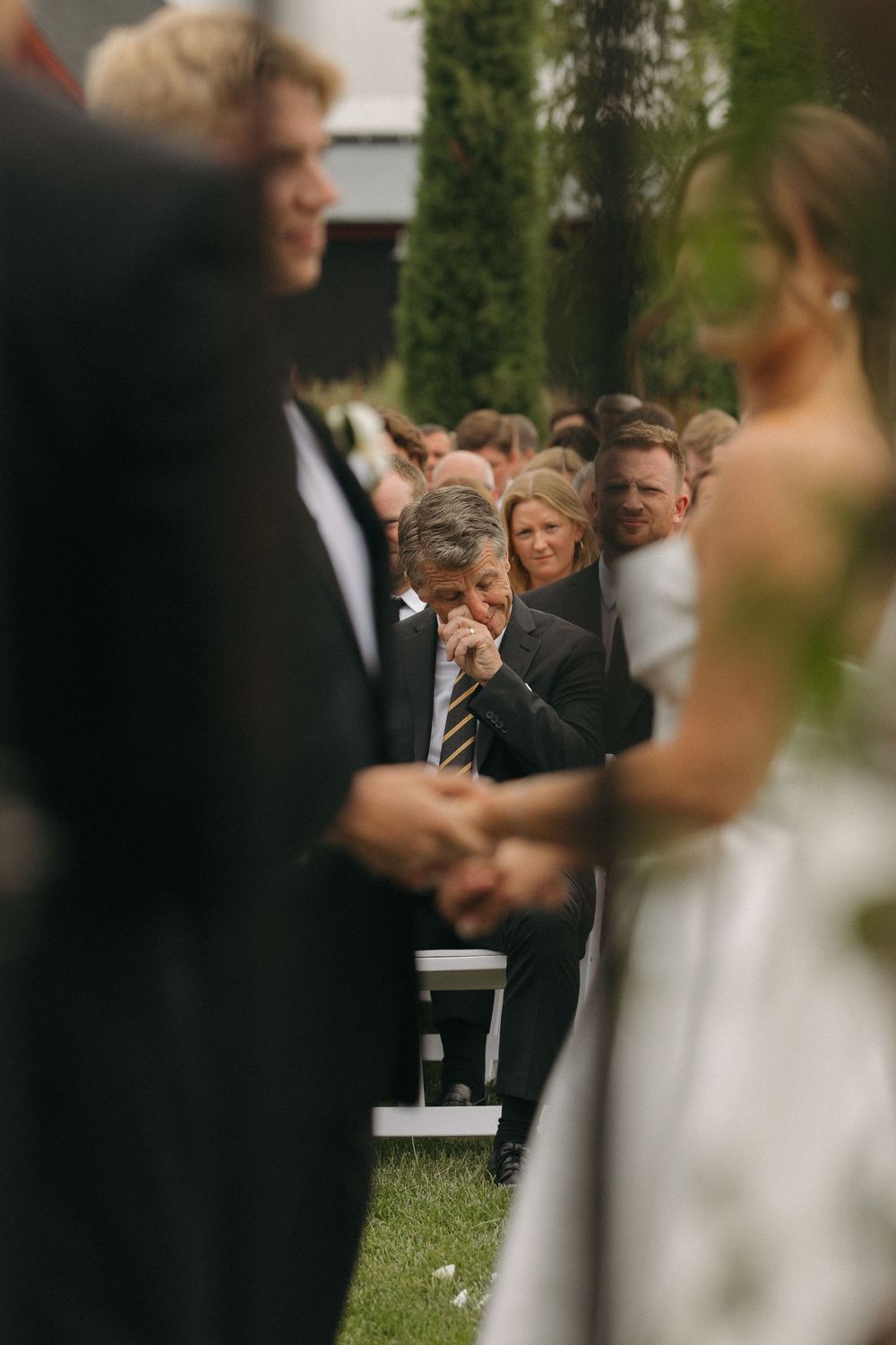 Wedding ceremony guests stand together during an intimate outdoor gathering.