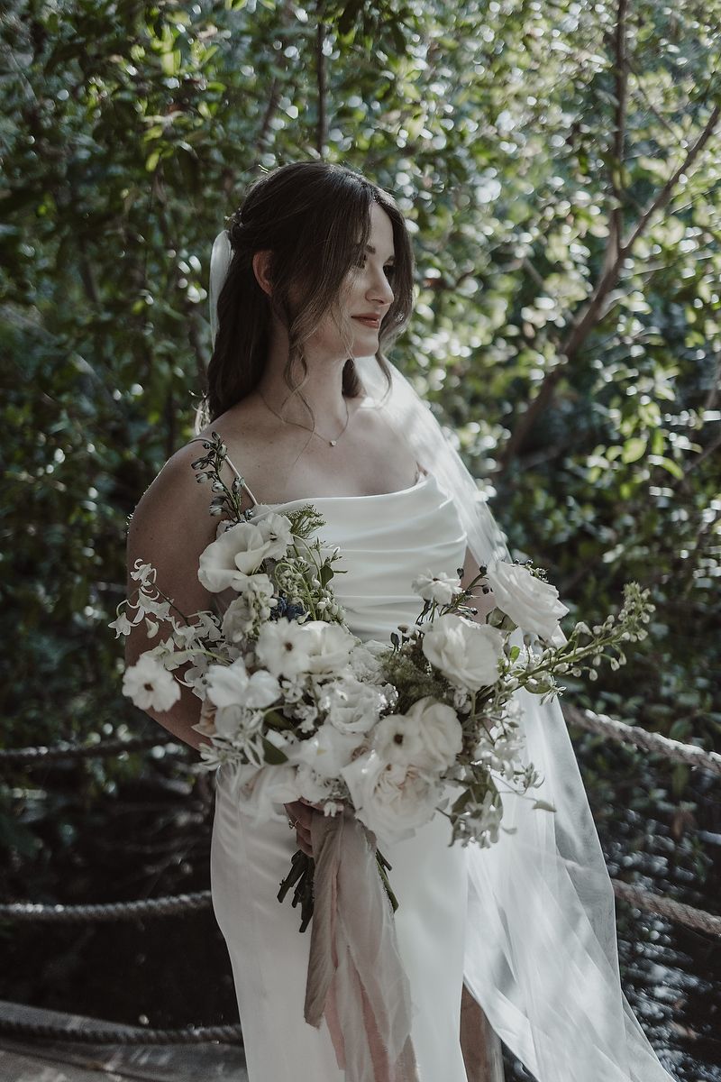 Bride holding bouquet in jungle garden during intimate elopement at La Valise Tulum Riviera Maya wedding photographer.