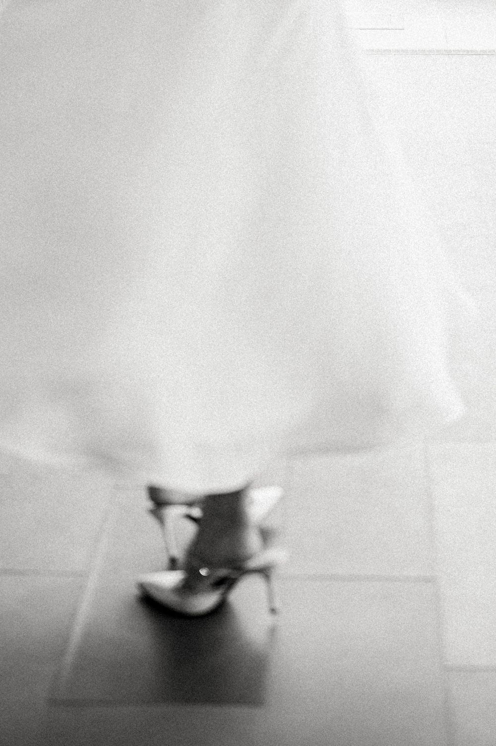 Blurred black and white image of a teacup on a tiled floor with a dreamy, abstract quality.