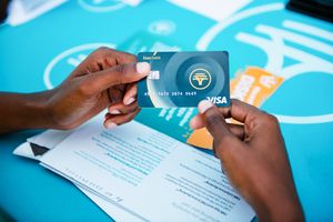 A close-up shot of of an FNB employee holding an FNB bank card at a corporate activation campaign in in Soweto South Africa.