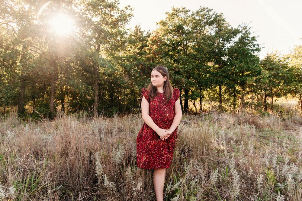 A scenic outdoor photo session in a golden field at sunset.