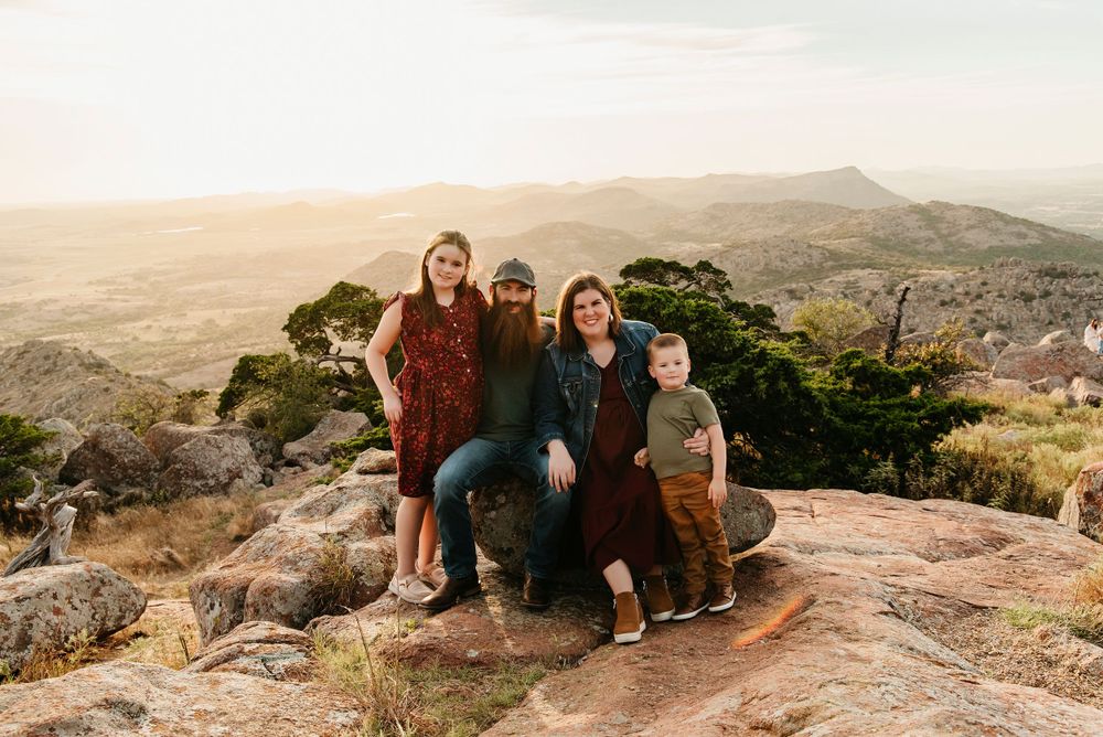 Scenic mountain landscape serves as backdrop for intimate couple photos on rocky terrain.