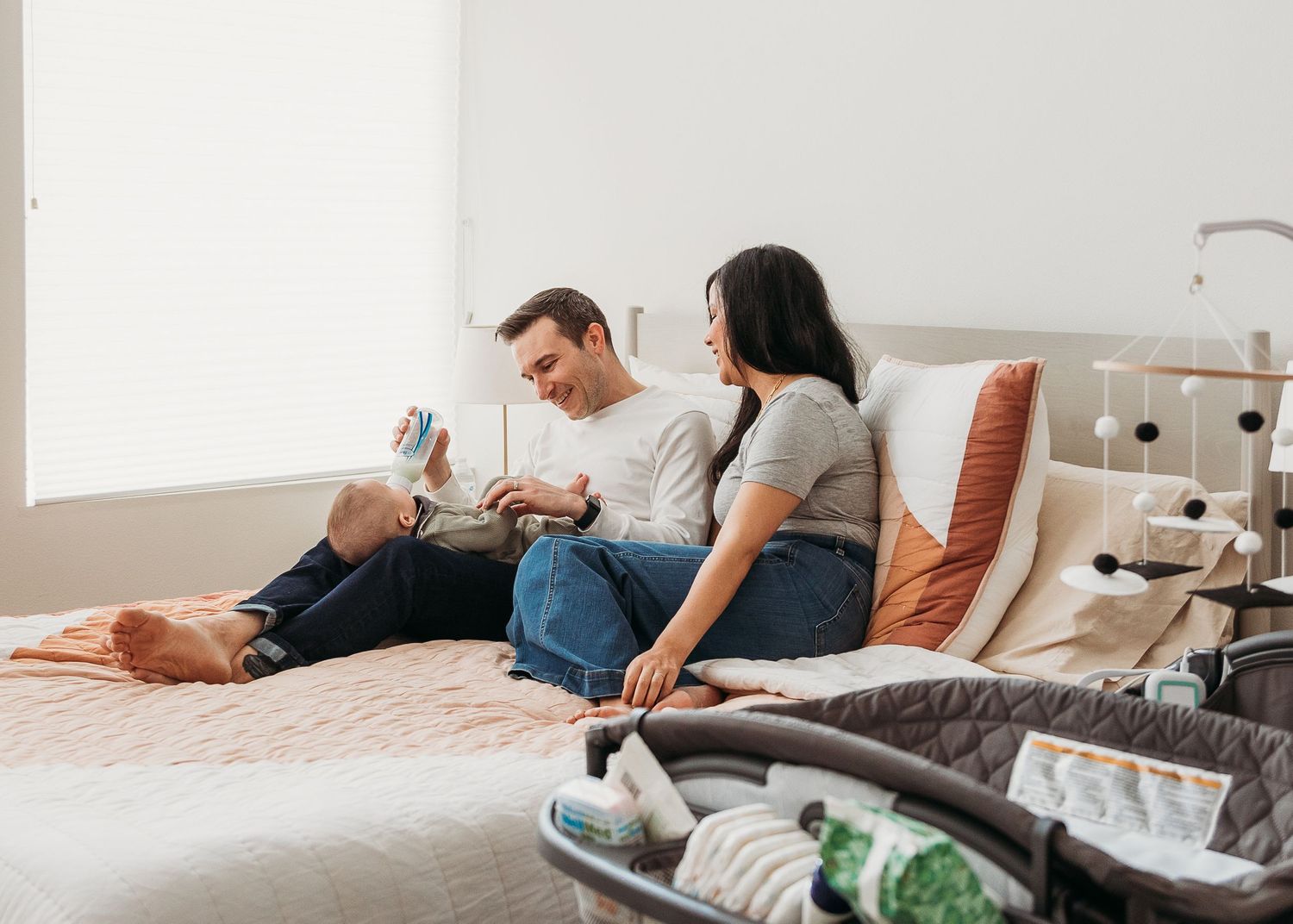 Couple relaxing on bed with casual clothing in bright modern bedroom.