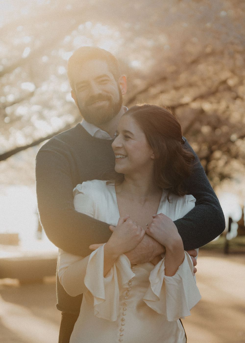 Couple embraces during golden hour portrait session outdoors.