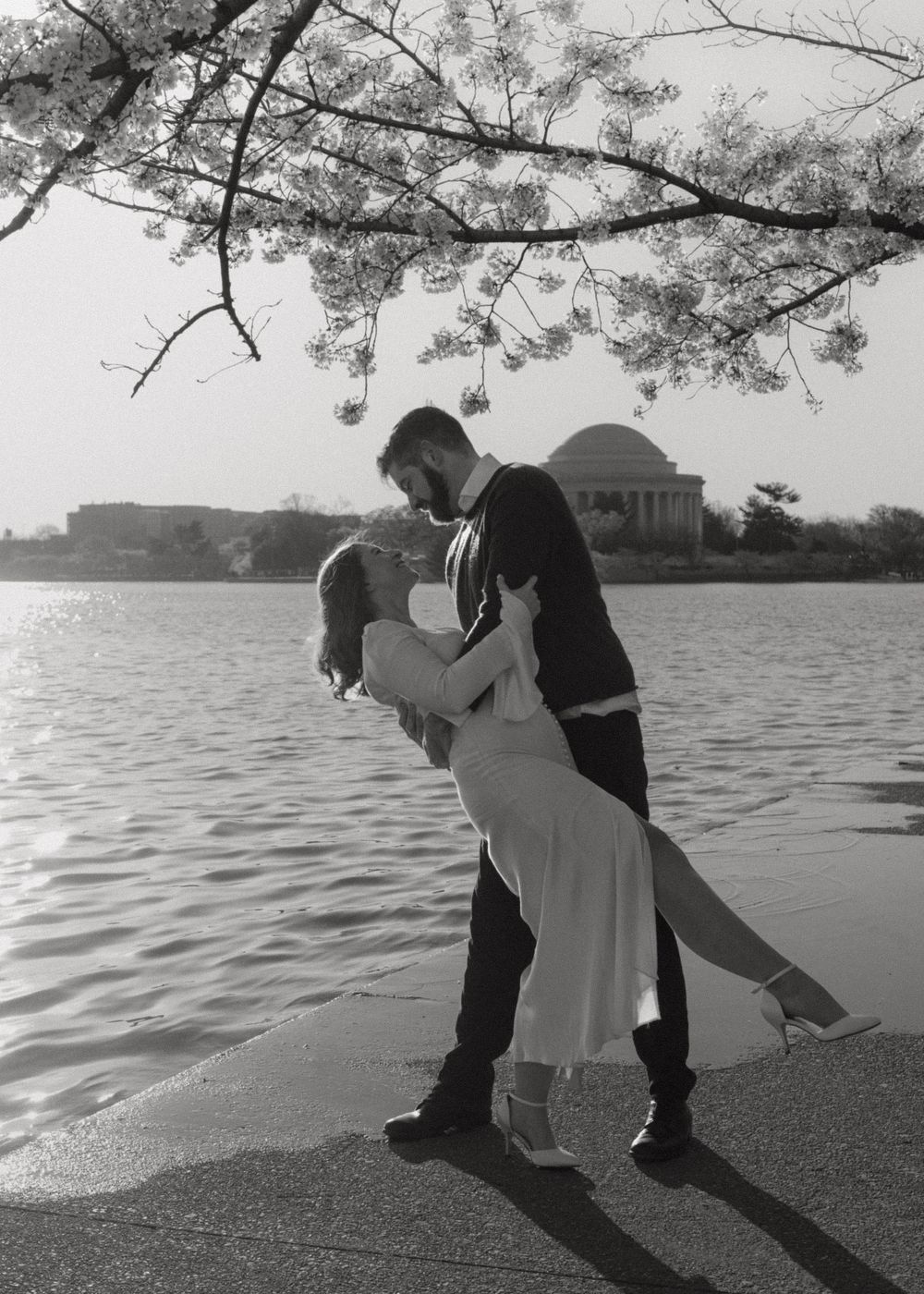 A romantic dip pose silhouetted against the Tidal Basin and Jefferson Memorial in black and white.