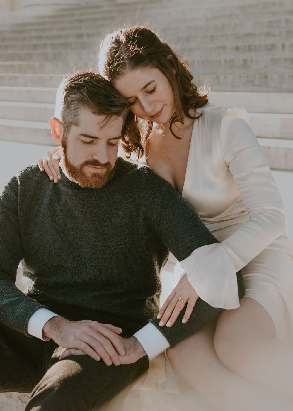 Intimate portrait of couple in casual attire sitting close together.