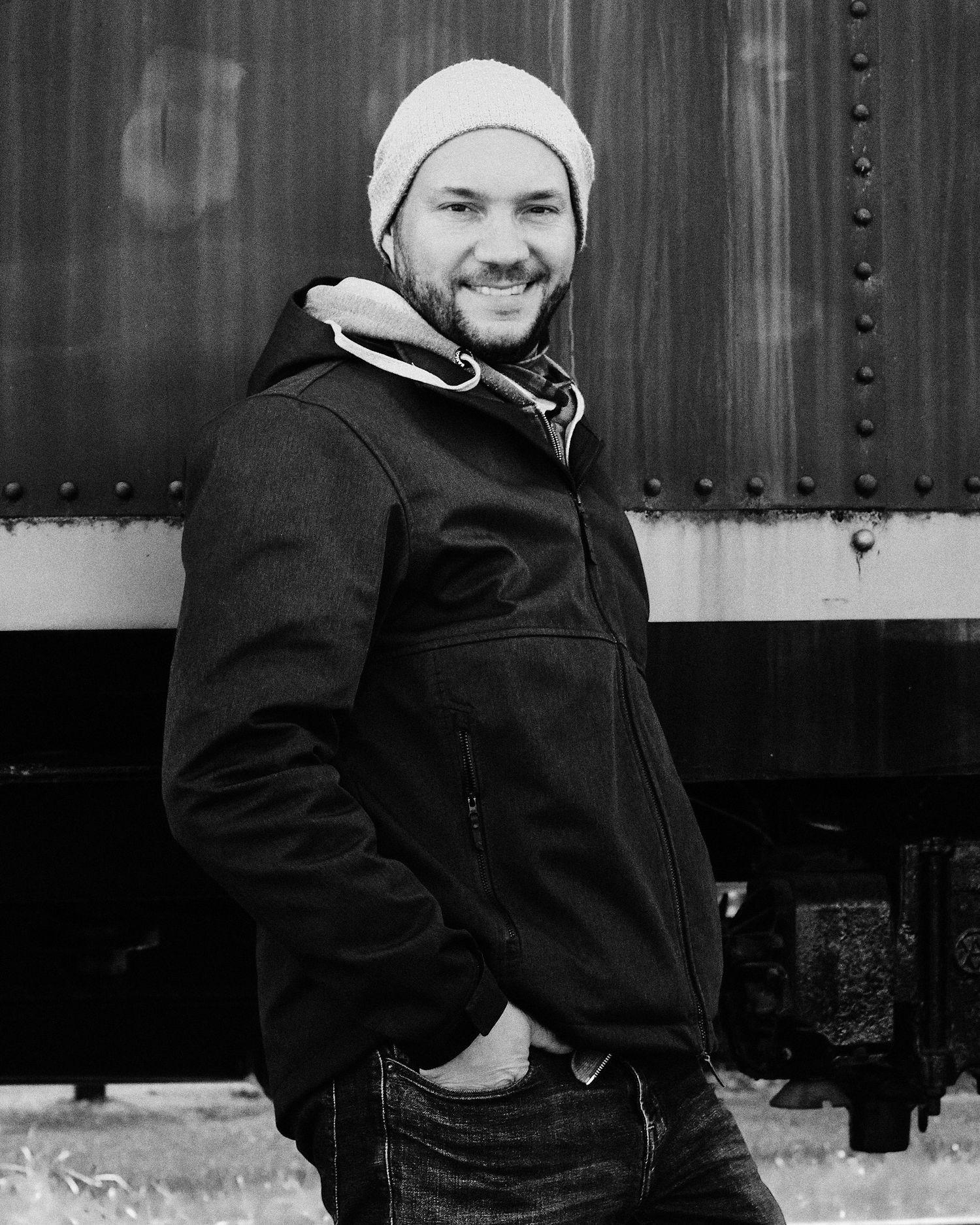 Image en noir et blanc d'un homme adossé à un mur.