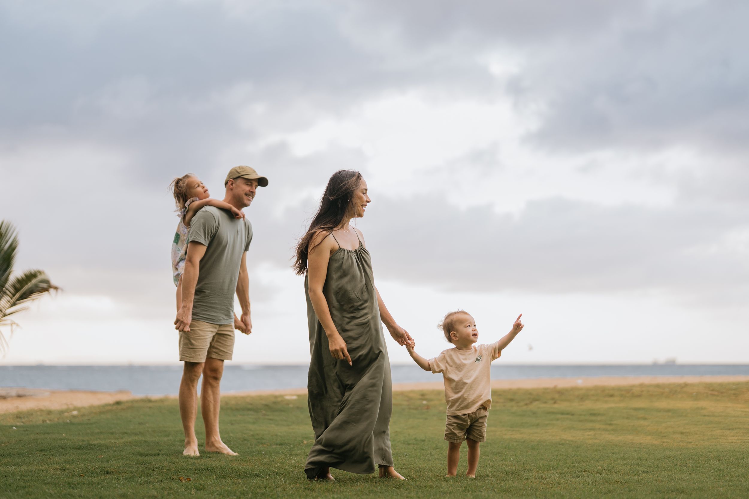 Beach family photography in Bali with an 
ocean backdrop.